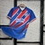 Camisa do Bahia 24/25, modelo manto 2, com cores azul, vermelho e detalhes em branco.