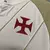 Detalhe da camisa do Vasco 24/25, mostrando o escudo vermelho em destaque na manga.