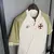 Camisa do Vasco 24/25, manto 3, em tom bege com detalhes em vermelho, pendurada em um cabide.