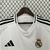 Camisa do Real Madrid 24/25, modelo manto 1, destacando o emblema do clube e detalhes em preto.