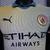 Camisa do Manchester City da temporada 24/25, com detalhes em azul e logotipo da Puma.