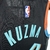 Regata NBA Washington Wizards City Edition 23/24 de Kyle Kuzma, destacando a numeração 33 e o design em preto com detalhes coloridos.