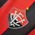 Detalhe do escudo do time Vitória na camisa 24/25, com as cores vermelho e preto e uma estrela amarela.