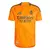 Camisa do Real Madrid 24/25 manto 2 em laranja com detalhes em preto e logo do clube.
