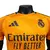 Camisa versão player do Real Madrid 24/25 na cor laranja, com detalhes em preto e logo do clube.