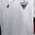 Camisa branca do Fortaleza 24/25 com detalhes em relevo e escudo do clube, incluindo o leão e a data de 1918.