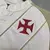 Detalhe da camisa feminina do Vasco 24/25, mostrando o emblema vermelho em destaque.