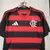 Camisa masculina do Flamengo, temporada 25/26, com listras vermelhas e pretas, logo do clube e detalhes em branco, urubu, escudo.