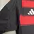 Camisa masculina do Flamengo, temporada 25/26, com listras vermelhas e pretas, logo do clube e detalhes em branco, urubu, escudo.