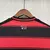 Camisa masculina do Flamengo, temporada 25/26, com listras vermelhas e pretas, logo do clube e detalhes em branco, urubu, escudo.