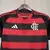 Camisa feminina do Flamengo 25/26, com listras vermelhas e pretas, destacando o emblema do clube e o logo da Adidas, com urubu.