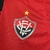 Camisa do Vitória da Copa do Nordeste 2025 feminina. com design em preto e vermelho, logo do clube e detalhes em amarelo, lampions. 
