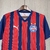 Camisa do Bahia puma torcedor Tricolor 25/26 com listras verticais vermelhas e azuis e logo do clube no peito.