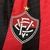 Camisa do Vitória volt Manto 1 temporada 2025/2026 com listras verticais vermelhas e pretas é uma linha branca, escudo bordado.