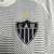 Detalhe do escudo da camisa do Atlético Mineiro 24/25, destacando a estrela e a sigla CAM em fundo branco.