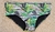 Low rise cut swimwear featuring a tropical leaf pattern on a striped background.