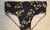 Black low rise swimwear with gold floral patterns