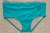 Blue swim trunks for men displayed on a sandy surface.