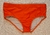 Orange classic swim trunks for men displayed on a sandy surface.