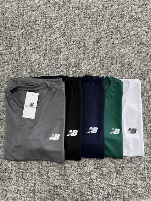 Camisetas dry fit New Balance juntas nas cores cinza, preto, azul-marinho, verde e branco