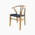 Silla Wishbone de madera natural con asiento tejido en negro.