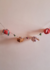Cordão decorativo com abóboras de crochê em cores variadas, ideal para decoração de festas de Halloween ou outono.