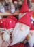 Três gnomos de feltro com chapéus vermelhos e um cogumelo decorativo ao lado, em um fundo colorido.