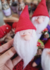 Gnomo mágico com chapéu vermelho e barba branca, segurando um pequeno cesto, em um ambiente decorativo.