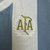Detalhe do escudo dourado da Associação de Futebol Argentino (AFA) em camisa listrada azul e branca