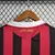 Detalhe das costas da camisa AC Milan I Retro 09/10, com listras vermelhas e pretas e bordado "AC Milan".