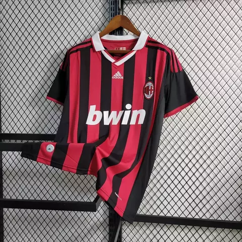 Camisa retro do AC Milan 09/10, vermelha e preta, com listras verticais e logo da Adidas.