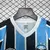 Detalhe do colarinho do kit infantil do Grêmio, nas cores azul e preto, com logo da Umbro.