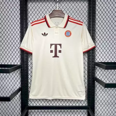 Camisa Third do Bayern de Munique para a temporada 24/25, na cor bege, com detalhes em vermelho e logo da Adidas.