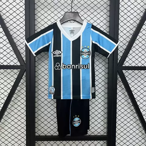 Kit infantil do Grêmio, camisa azul e preta, com detalhes em azul claro e logotipos da Umbro e Banrisul.