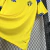 Camisa oficial da seleção masculina da Suécia 2026/2027, amarela com detalhes em azul e branco, pendurada em cabide