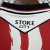 Camisa masculina oficial do Stoke City 2025/2026 com listras verticais vermelhas e brancas e patrocínio bet365