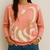 Suéter Bremer color coral con diseño abstracto en tonos beige y blanco, ideal para un look casual.