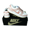 Zapatillas Nike Dunk Low en tonos blanco y rosa, con detalles en la suela y cordones gris oscuro.