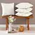 Kit 4 Capas de Almofadas 45x45cm na cor Off-White, modelo 3D Quadrada Aveline da Bia Enxovais, sobre banco de madeira ao lado de decoração delicada com flores e vela. Envio de São Luís/MA para todo o Brasil.