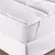 Pillow Top Solteiro Suavitec branco em micro percal 200 fios, detalhe da lateral com elástico ajustável, sobre um colchão branco com base texturizada. A imagem destaca a textura acolchoada do pillow top e como ele se ajusta perfeitamente ao colchão. Envio