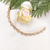 Pulseira cravejada de zircônias em ouro 18K, ao lado de um perfume Twilly d'Hermès Eau Ginger.