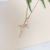 Colar em ouro 18K com pingente em forma de cruz cravejado de zircônias.