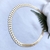Colar choker em ouro 18K com design de coroa de louros, exibindo um padrão elegante e sofisticado.