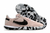 Chuteira Nike Streetgato Futsal em tom rosa com detalhes em preto e solado camuflado.