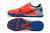 Chuteira Nike React Gato Futsal em destaque, com parte superior em laranja e detalhes em azul e preto.