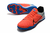 Chuteira Nike React Gato Futsal em destaque, com parte superior em laranja e detalhes em azul e preto.