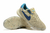 Chuteira Nike Streetgato Futsal em tom bege com detalhes azuis e sola colorida.