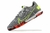 Chuteira Nike React Gato Futsal com design moderno em tons de cinza, verde e vermelho.