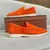 Mocassim masculino Old Money na cor laranja, com detalhe em costura e sola branca, ao lado de uma caixa marrom.