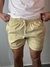 Shorts de linho amarelo com cordão na cintura, usado por um homem.